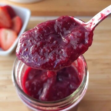 A spoonful of no sugar added chia jam hovering over the jam jar
