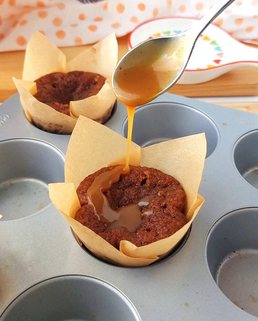 Adding toffee sauce drizzle to warm sticky toffee pudding so it soaks in